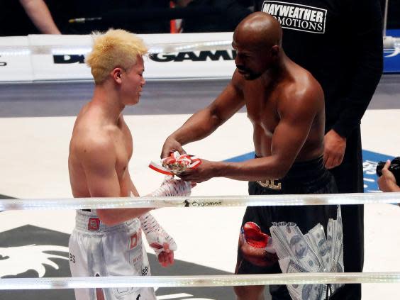 Mayweather attempts to hand Nasukawa the trophy (Reuters)