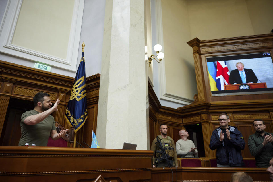 In this image released by the Ukrainian Presidential Press Office, Ukrainian President Volodymyr Zelenskyy, left, waves to a screen showing Britain's Prime Minister Boris Johnson via videolink, during a session at Ukraine's parliament, in Kyiv, Ukraine, Tuesday, May 3, 2022. (Ukrainian Presidential Press Office via AP)