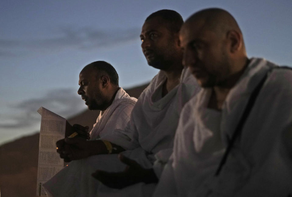 Muslim pilgrims pray on top of the rocky hill known as the Mountain of Mercy, on the Plain of Arafat, during the annual hajj pilgrimage, near the holy city of Mecca, Saudi Arabia, Friday, July 8, 2022. (AP Photo/Amr Nabil)