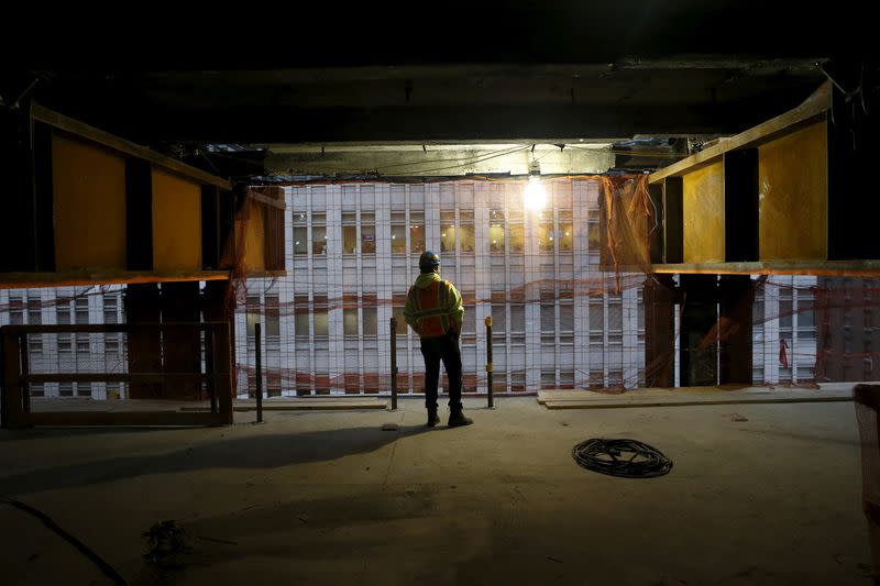 FILE PHOTO: A worker is seen between two massive support beams inside 390 Madison Avenue, an office building in midtown Manhattan in New York that is undergoing a complete re-construction in New York