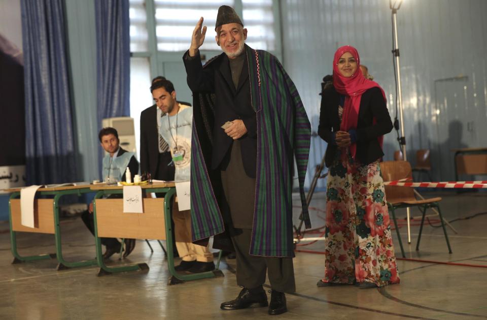 Afghan President Hamid Karzai, center, greets before he casts his vote at Amani high school, near presidential palace in Kabul, Afghanistan, Saturday, April 5, 2014. Afghan voters lined up for blocks at polling stations nationwide on Saturday, defying a threat of violence by the Taliban to cast ballots in what promises to be the nation's first democratic transfer of power. (AP Photo/Massoud Hossaini)