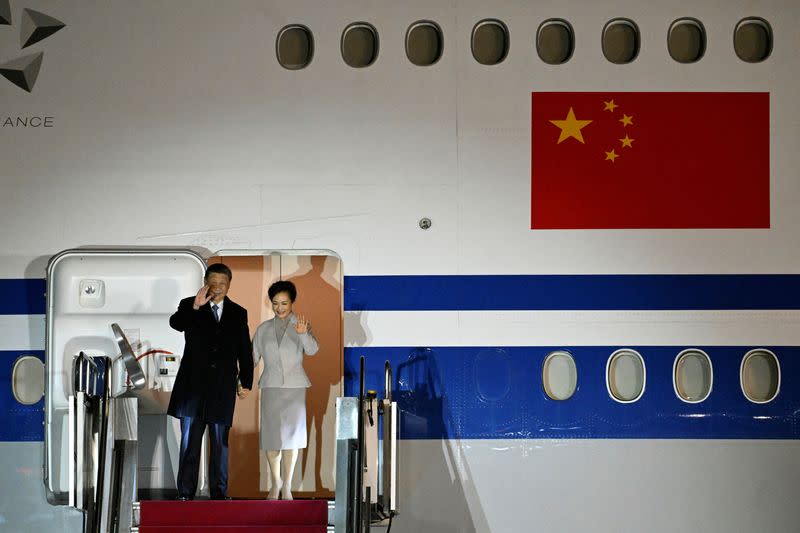 Chinese President Xi Jinping and his wife Peng Liyuan wave as they arrive at the Ferenc Liszt International Airport in Budapest