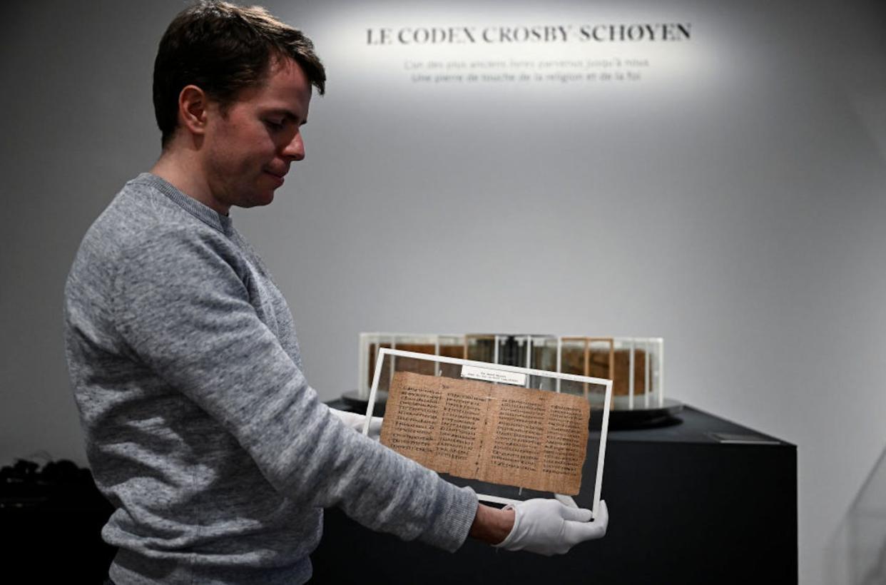 The Crosby-Schoyen Codex at Christie's auction house in Paris. The manuscript goes up for auction in London on June 11, 2024. <a href="https://www.gettyimages.in/detail/news-photo/an-employee-holds-the-crosby-schoyen-codex-a-manuscript-news-photo/2149295541" rel="nofollow noopener" target="_blank" data-ylk="slk:Julien De Rosa/AFP via Getty Images;elm:context_link;itc:0;sec:content-canvas" class="link ">Julien De Rosa/AFP via Getty Images</a>