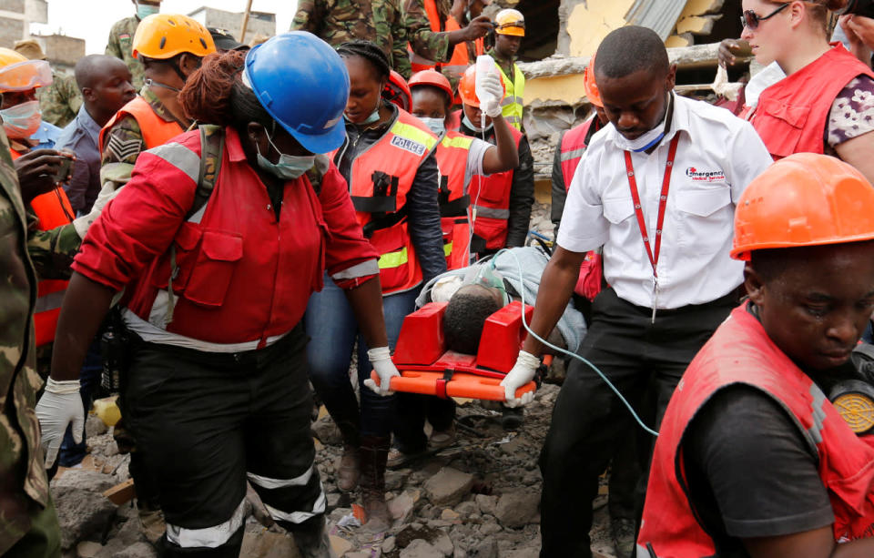 <p>Kenya Red Cross rescuers evacuate a woman from the rubble of a six-story building that collapsed last Friday after days of heavy rain, in Nairobi, Kenya May 5, 2016. <i>(Photo: Thomas Mukoya/Reuters)</i></p>