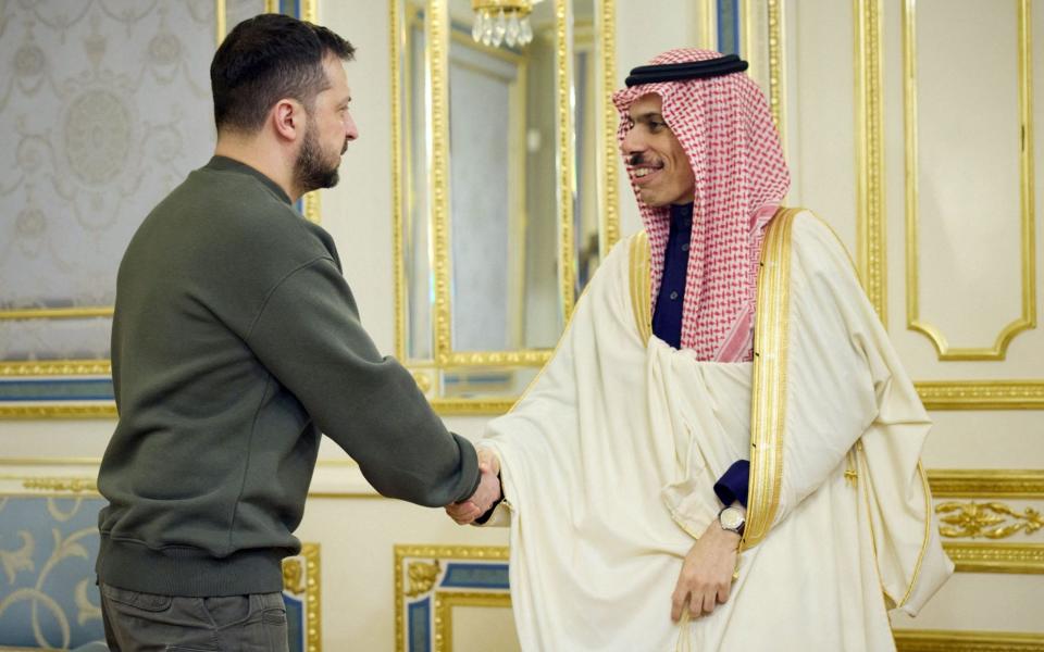 This handout picture taken and released by the Ukrainian Presidential press service on February 26, 2023, shows Ukrainian President Volodymyr Zelensky (L) shaking hands with Foreign Minister of the Kingdom of Saudi Arabia Prince Faisal bin Farhan Al Saud - HANDOUT/AFP