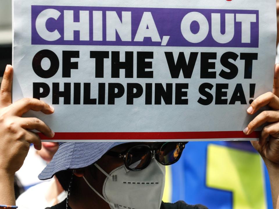 A protester holds a sign criticising China’s actions against Philippine vessels in disputed waters of the South China Sea during a rally outside China’s consular office in Makati City, Metro Manila, Philippines, on 11 June 2024 (EPA)