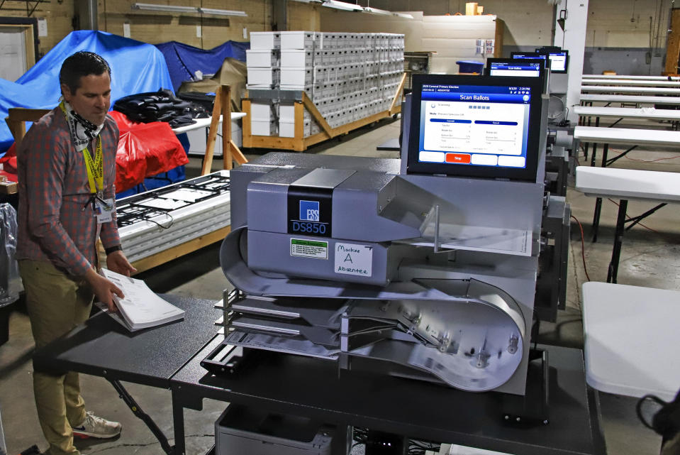 Allegheny County Election Division Deputy Manager Chet Harhut demonstrates a mail-in and absentee ballot counting machine at the Elections warehouse in Pittsburgh on June 1, 2020. (Gene J. Puskar/AP)