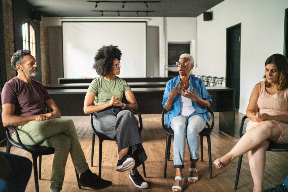 group of people sitting in chairs in a circle