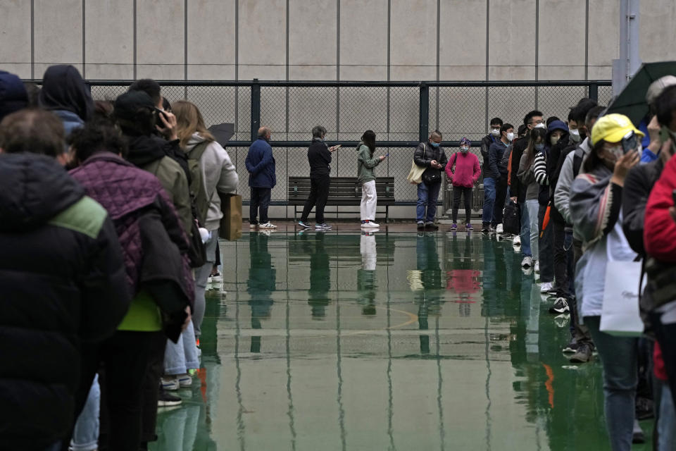 Despite the rain, residents line up to get tested for the coronavirus at a temporary testing center in Hong Kong, Thursday, Feb. 17, 2022. Hong Kong on Thursday reported 6,116 new coronavirus infections, as the city’s hospitals reached 90% capacity and quarantine facilities are at their limit, authorities said. (AP Photo/Kin Cheung)