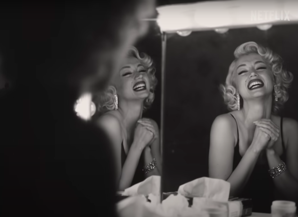 Marilyn laughs while looking at herself in the mirror