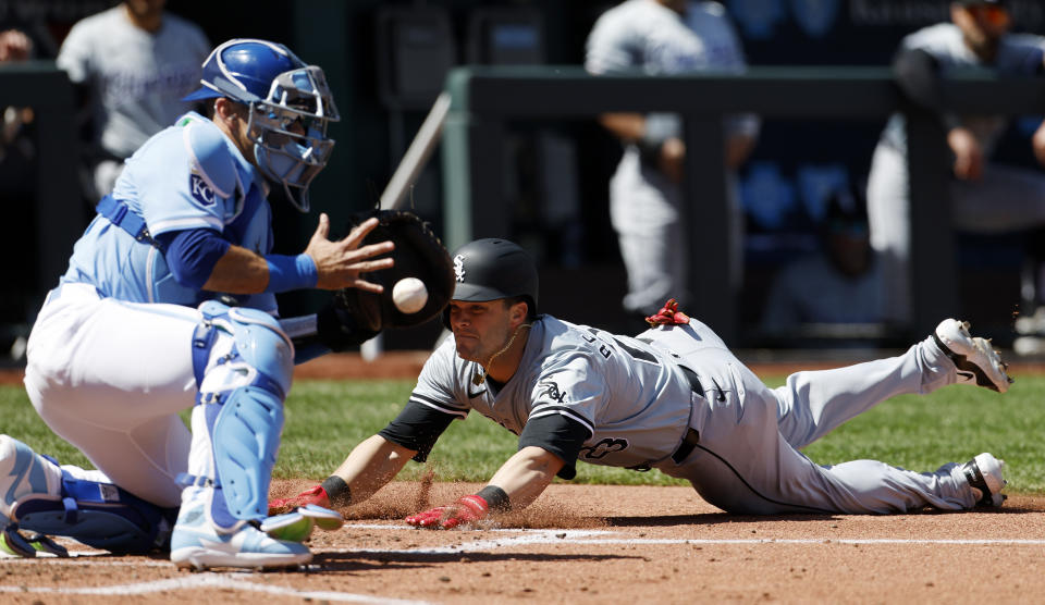 Chicago White Sox' Andrew Benintendi, right, scores off a Dominic Fletcher triple as Kansas City Royals catcher Freddy Fermin, left, catches a late throw during the fourth inning of a baseball game in Kansas City, Mo., Sunday, April 7, 2024. (AP Photo/Colin E. Braley)