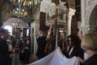 Orthodox faithful take part in a ceremony of the Deposition of Jesus Christ at Saint Catherine church, in Athens, Greece, Friday, April 22, 2022. For the first time in three years, Greeks were able to celebrate Easter without the restrictions made necessary by the coronavirus pandemic. (AP Photo/Yorgos Karahalis)