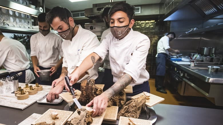 Chefs cutting meat in Disfrutar restaurant kitchen