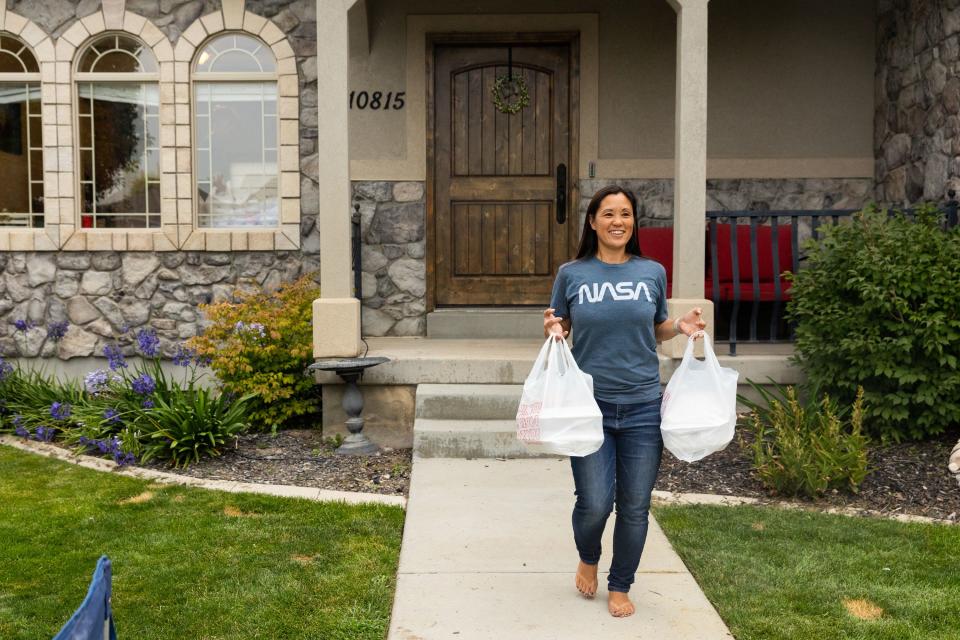 Jenny Wunder brings out food at a dinner plate sale she organized where the proceeds will go to aiding Maui at her home in Cedar Hills on Saturday, Aug. 19, 2023. | Megan Nielsen, Deseret News