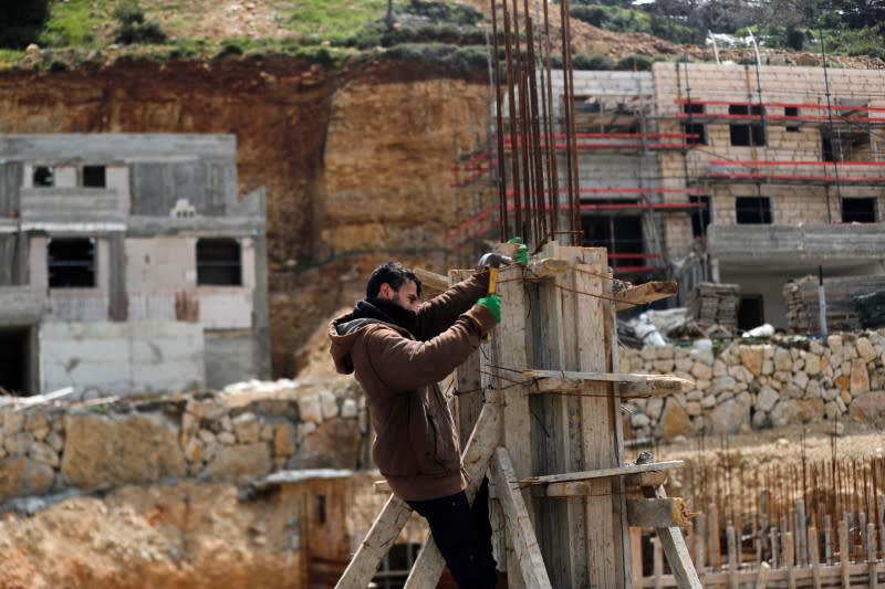 A Palestinian Labourer works at a construction site in the Israeli settlement of Ramat Givat Zeev in the Israeli-occupied West Bank