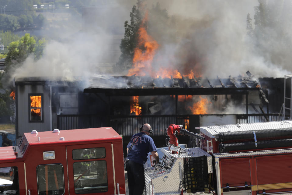 Construction buildings burn near the King County Juvenile Detention Center, Saturday, July 25, 2020, in Seattle, shortly after protesters left the area. A large group of protesters were marching Saturday in Seattle in support of Black Lives Matter and against police brutality and racial injustice. Protesters broke windows and vandalized cars at the facility. (AP Photo/Ted S. Warren)