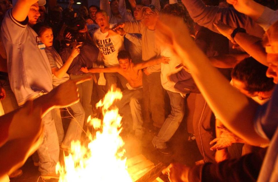 A UNC fan prepares to jump over a bonfire in the middle of Franklin St. in downtown Chapel Hill after UNC’s victory over Duke Sunday, March 6, 2005.