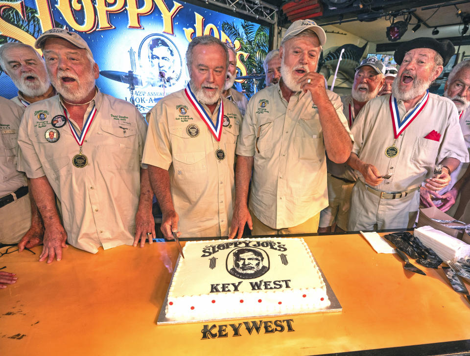In this photo provided by the Florida Keys News Bureau, previous Hemingway Look-Alike Contest winners including, from left, David Douglas, Zach Taylor and Jon Auvil, as well as honorary look-alike Brian Sinclair, sing "Happy Birthday" to Ernest Hemingway, Thursday, July 20, 2023, on the eve of the late author's 124th birthday anniversary, at Sloppy Joe's Bar in Key West, Fla. The birthday commemoration preceded the first round of the 2023 Hemingway Look-Alike Contest, a highlight of the island's annual Hemingway Days festival. The famed American author lived and wrote in Key West for most of the 1930s. (Andy Newman/Florida Keys News Bureau via AP)
