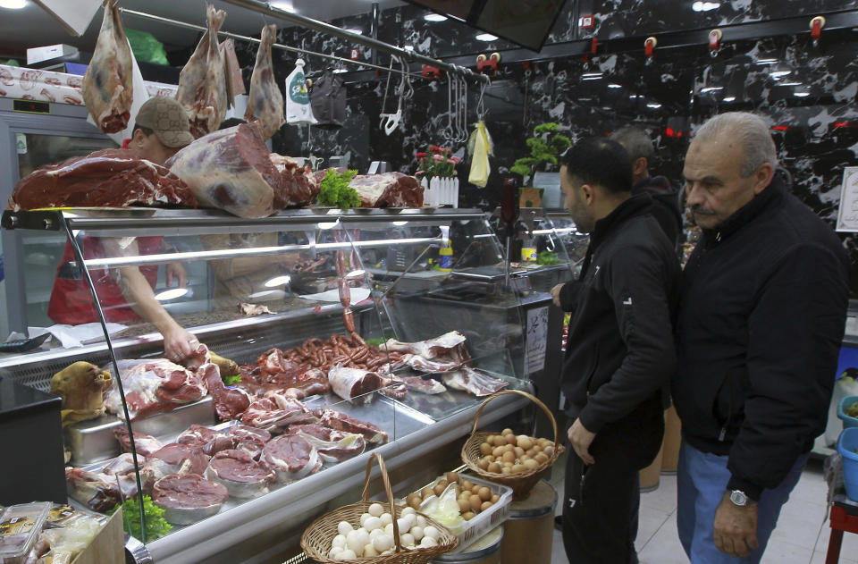 People shop for beef in a butchery in Algiers, Algeria, Sunday, Feb. 18, 2024. Algeria is importing massive amounts of beef and lamb to confront an explosion in demand for meat expected throughout the Muslim holy month of Ramadan, hoping to stabilize prices as the country's economy continues to struggle. The oil-rich North African nation is among countries working to import food and fuel, hoping to meet the requirements of Algerians preparing nightly feasts as their families break their sunrise-to-sunset fasts. (AP Photo/Fateh Guidoum)