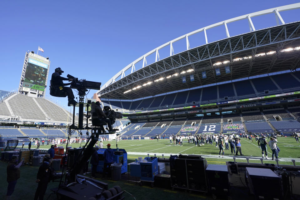 Two TV cameras mounted on a moving cart stand ready to capture action before an NFL football game between the Seattle Seahawks and the San Francisco 49ers, Sunday, Nov. 1, 2020, in Seattle. No fans were allowed in CenturyLink Field for the game due to the COVID-19 pandemic, leaving the TV broadcast as the only way for fans to experience the game. (AP Photo/Elaine Thompson)