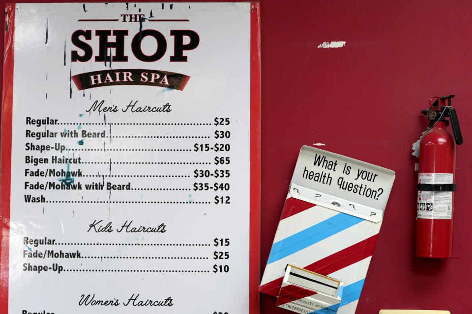 A box encouraging barber shop patrons to submit health questions is displayed at The Shop, Friday, April 9, 2021, in Hyattsville, Md. Barbers are member of the Health Advocates In Reach & Research (HAIR) program, which helps barbers and hair stylists to get certified to talk to community members about health. During the COVID-19 pandemic, a team of certified barbers have been providing factual information to customers about vaccines, a topic that historically has not been trusted by members of black communities because of the health abuse the race has endured over the years. (AP Photo/Julio Cortez)