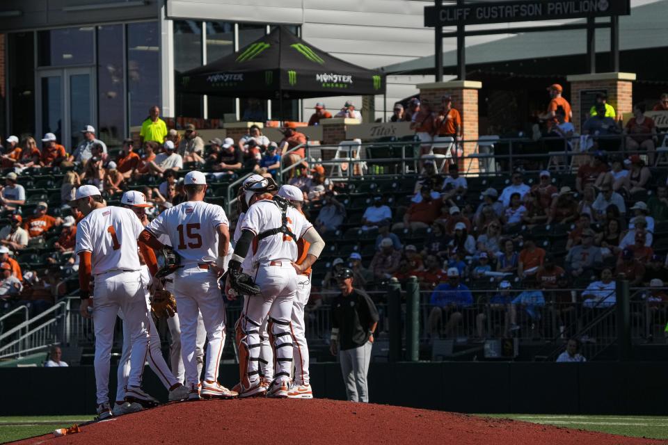 Texas players have a discussion with pitcher Cody Howard during their Feb. 24 game in Austin against Cal Poly. Howard was chased in the fifth inning Sunday by Vanderbilt, which went on to rally for a 14-11 win in Houston.