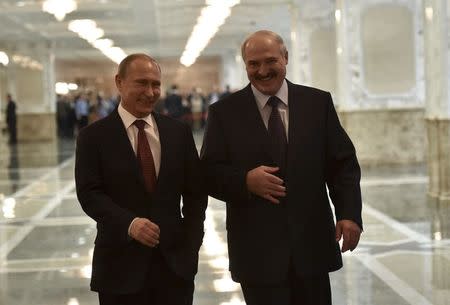 Russia's President Vladimir Putin (L) and Belarus' President Alexander Lukashenko laugh while walking before a meeting on resolving the Ukrainian crisis in Minsk, February 11, 2015. REUTERS/Mykola Lazarenko/Ukrainian Presidential Press Service/Handout via Reuters