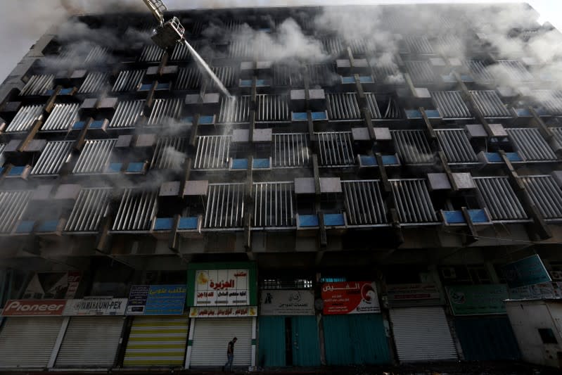 Firemen hose down a burning building in Baghdad