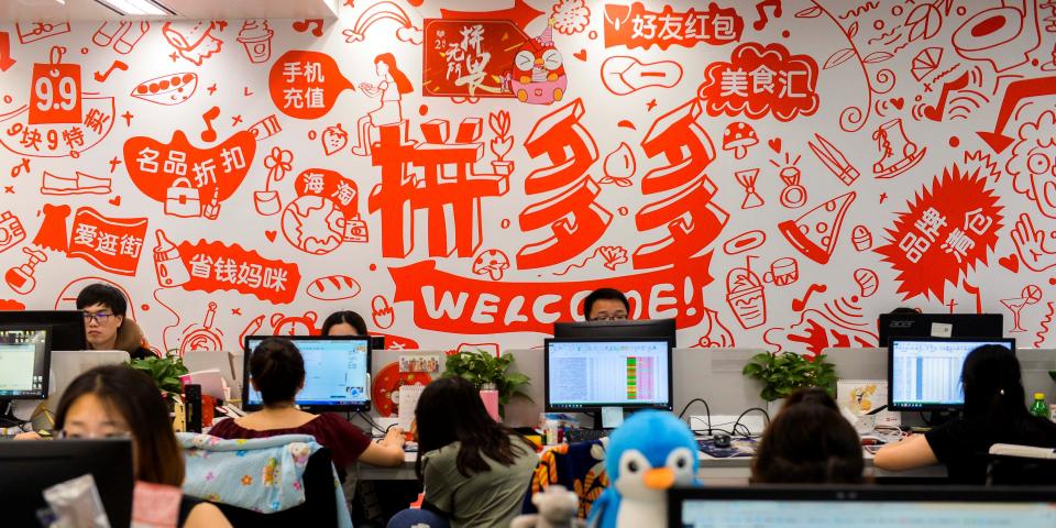 FILE PHOTO: People are seen at their desks at the headquarters of Chinese online group discounter Pinduoduo in Shanghai, China July 25, 2018. REUTERS/Stringer 