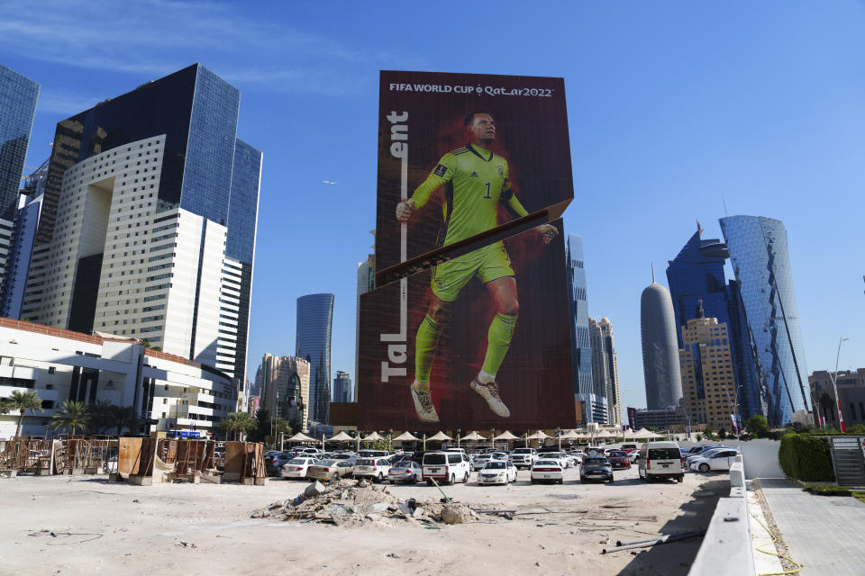 A construction cite is seen in front of a building with a Germany's goalkeeper Manuel Neuer's portrait in Lusail downtown, Qatar, Thursday, Nov. 24, 2022. (AP Photo/Pavel Golovkin)