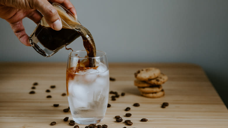 man pouring Americano with cookies