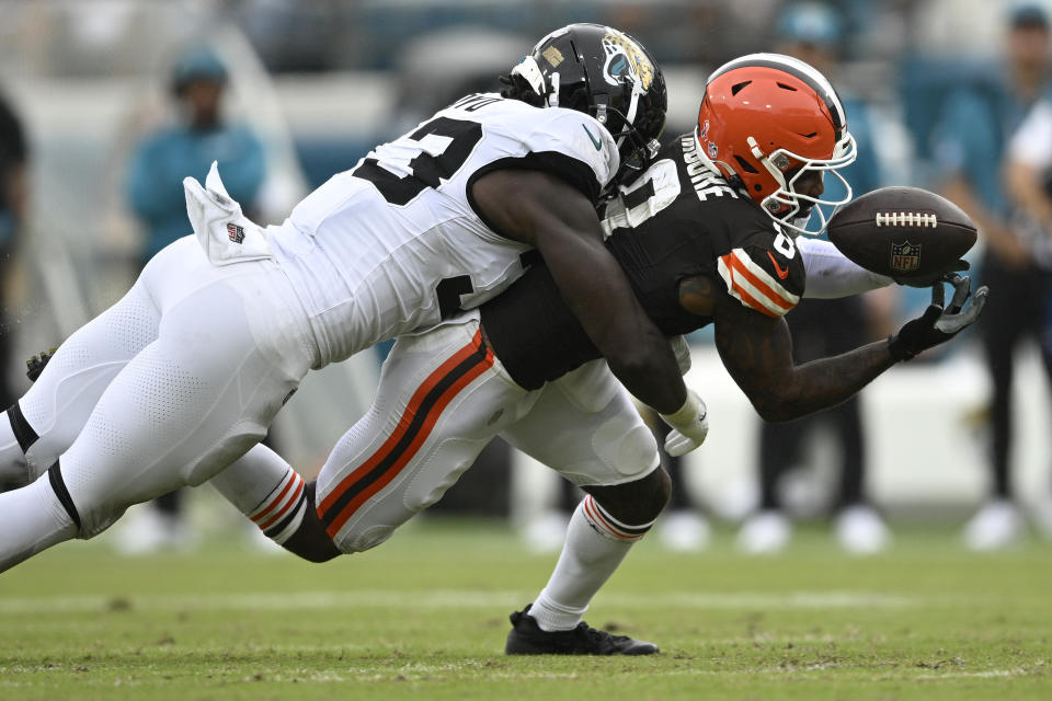 Cleveland Browns wide receiver Elijah Moore (8) drops a pass as he gets hit by Jacksonville Jaguars linebacker Devin Lloyd (33) during the second half of an NFL football game Sunday, Sept. 15, 2024, in Jacksonville, Fla. (AP Photo/Phelan M. Ebenhack)