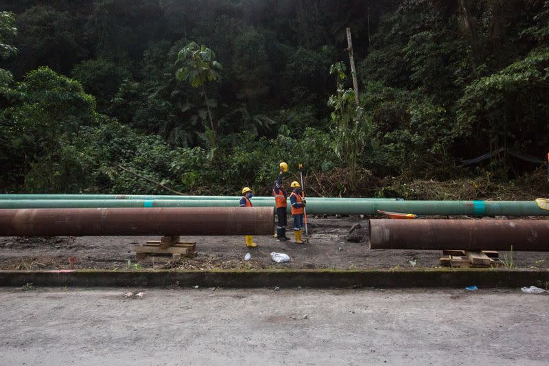 Workers repair a section of oil pipeline about 25 km from the city of Tena in the Amazon