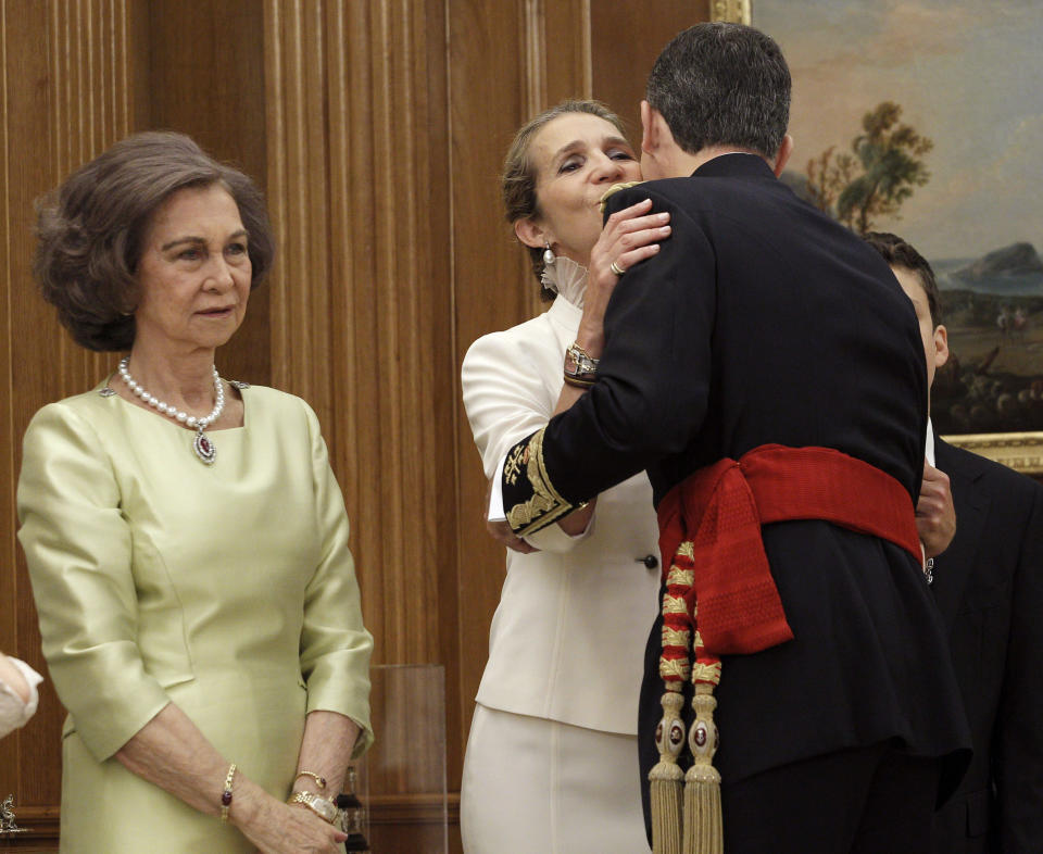 Spain's new King Felipe VI (R), wearing the Sash of Captain-General, kisses Infanta Elena next to his mother Queen Sofia (L) during a ceremony at La Zarzuela Palace in Madrid, June 19, 2014. Spain's new king, Felipe VI, will be sworn in on Thursday in a low-key ceremony which monarchists hope will usher in a new era of popularity for the troubled royal household.      REUTERS/Zipi/Pool (SPAIN  - Tags: ROYALS POLITICS ENTERTAINMENT)  