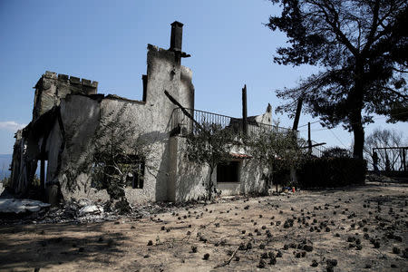 A burned house is seen following a wildfire near the village of Kalamos, north of Athens, Greece, August 14, 2017. REUTERS/Costas Baltas