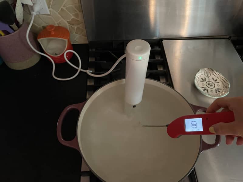 Thermometer taking temperature of sous vide water bath.