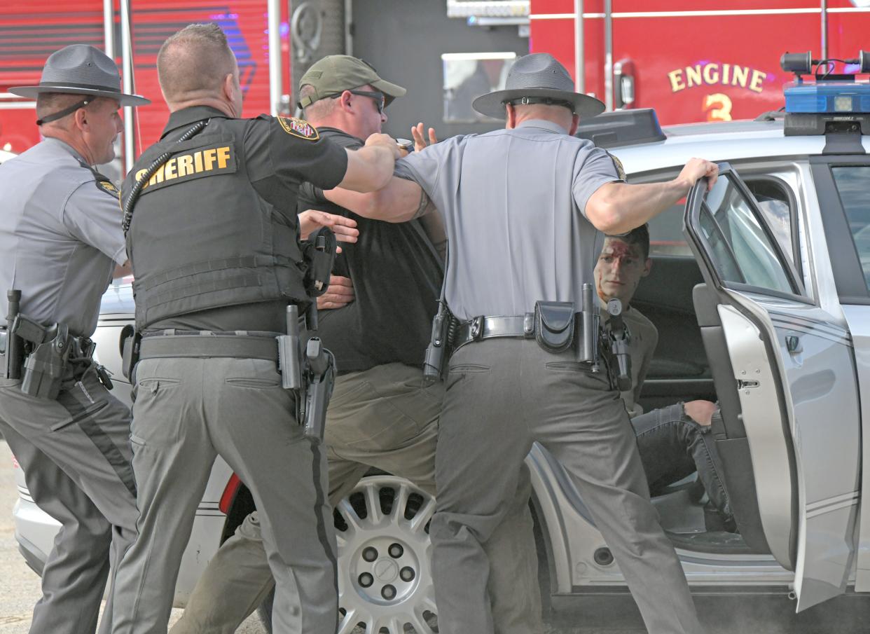 Actors create a tense moment during the moch crash dramatization at the Richland County Fairgrounds on Tuesday morning.