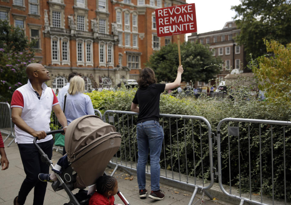 An Anti-Brexit supporter shouts slogans towards where the media is gathered, near the Houses of Parliament in London, Wednesday, Aug. 28, 2019. British Prime Minister Boris Johnson asked Queen Elizabeth II on Wednesday to suspend Parliament, throwing down the gauntlet to his critics and causing outrage among opposition leaders who will have even less time to thwart a no-deal Brexit. (AP Photo/Matt Dunham)