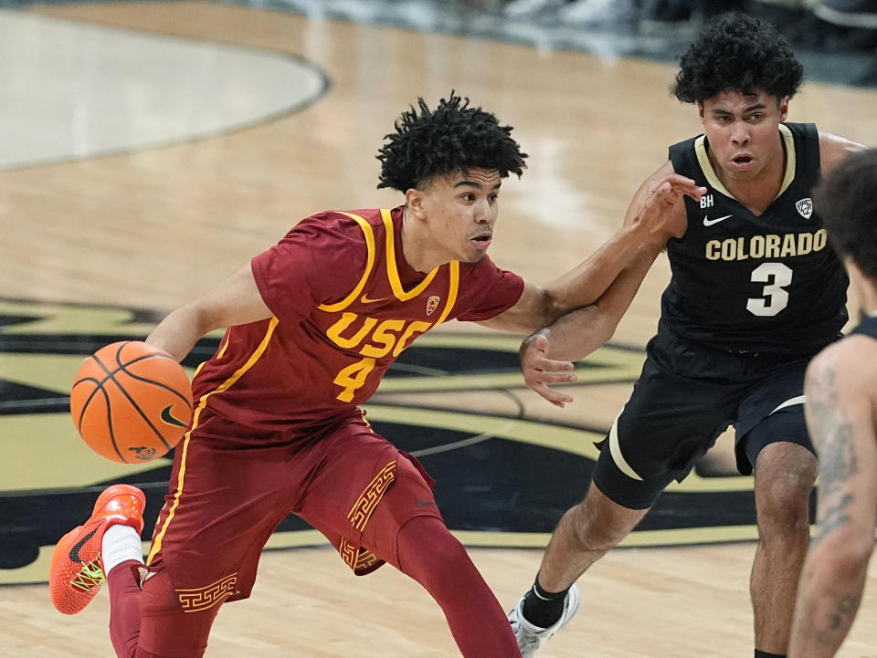 Southern California guard Oziyah Sellers, left, drives past Colorado guard Julian Hammond III in the first half of an NCAA college basketball game Saturday, Jan. 13, 2024, in Boulder, Colo. (AP Photo/David Zalubowski)