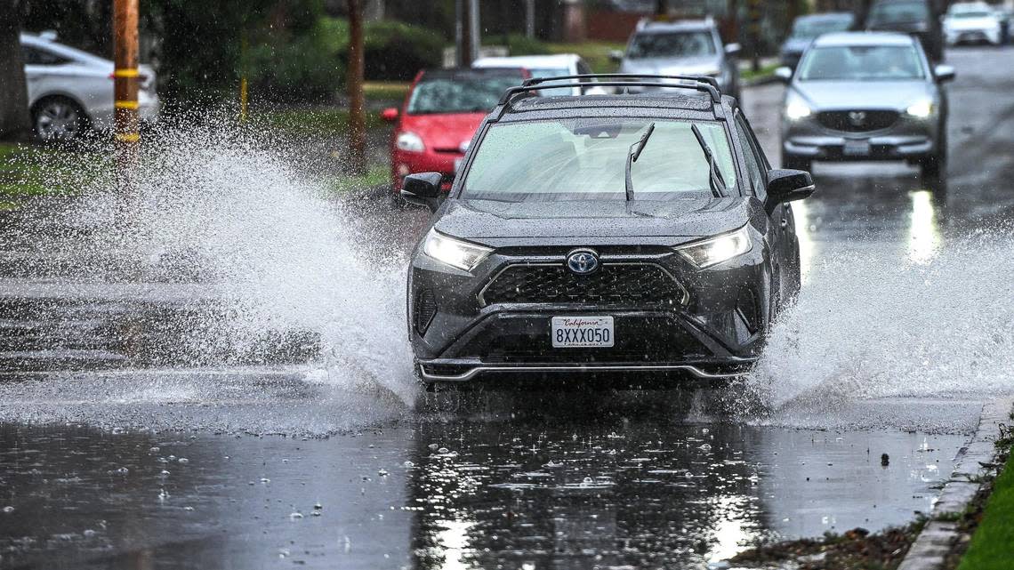 Cars drive through flooded streets at Clinton and Van Ness in Fresno during a heavy downpour, the first of several weekend storms expected, on Saturday, Jan. 14, 2023.