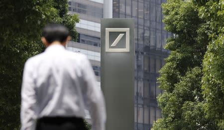 A man walks near a logo of Deutsche Bank AG in Tokyo July 16, 2014. REUTERS/Toru Hanai/Files