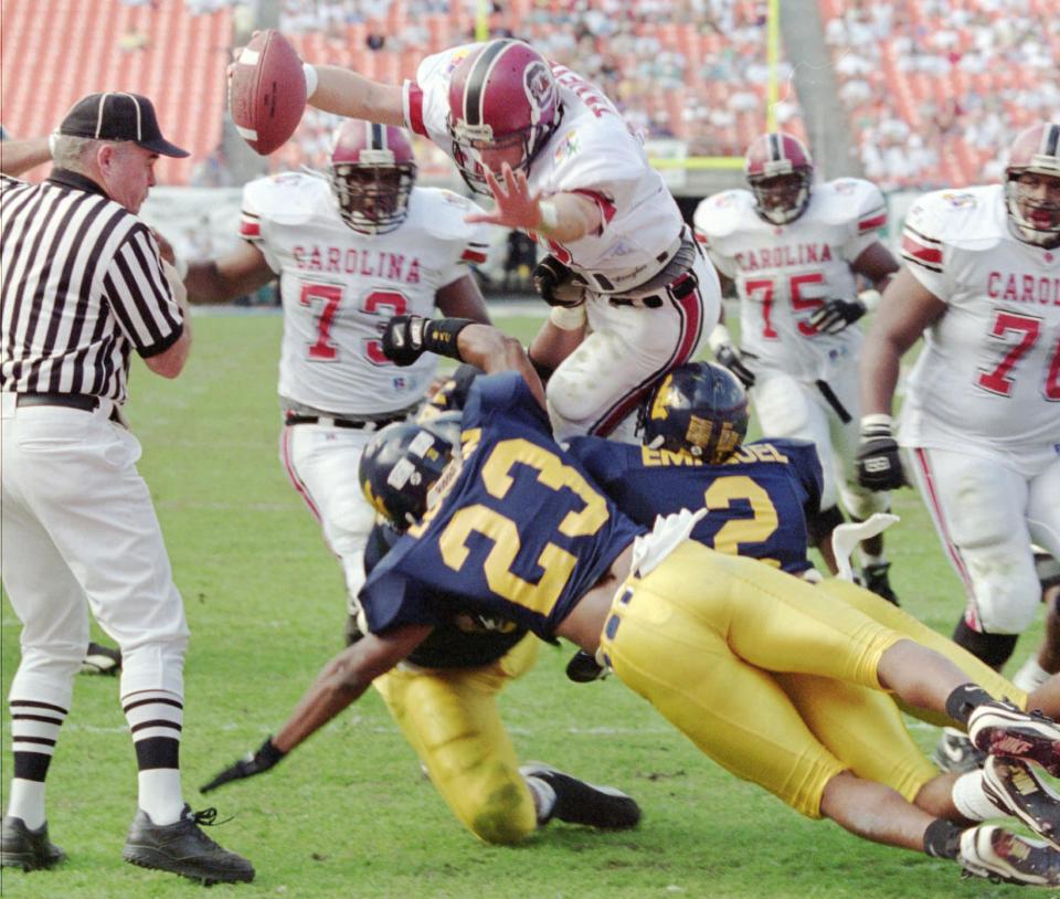 South Carolina quarterback Steve Taneyhill (18) goes up and over West Virginia's Mike Logan (23) for a touchdown in second quarter action in the CarQuest Bowl in Miami, Monday, Jan. 2, 1995. (AP Photo/Jeffrey Boan)