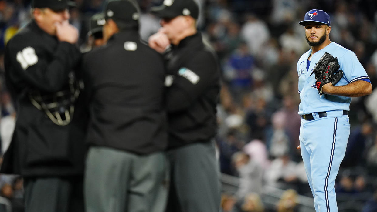 Toronto Blue Jays relief pitcher Yimi Garcia watches as home plate umpire Lance Barrett, left, talks with other umpires after Garcia hit New York Yankees' Josh Donaldson with a pitch during the sixth inning. (AP Photo/Frank Franklin II)