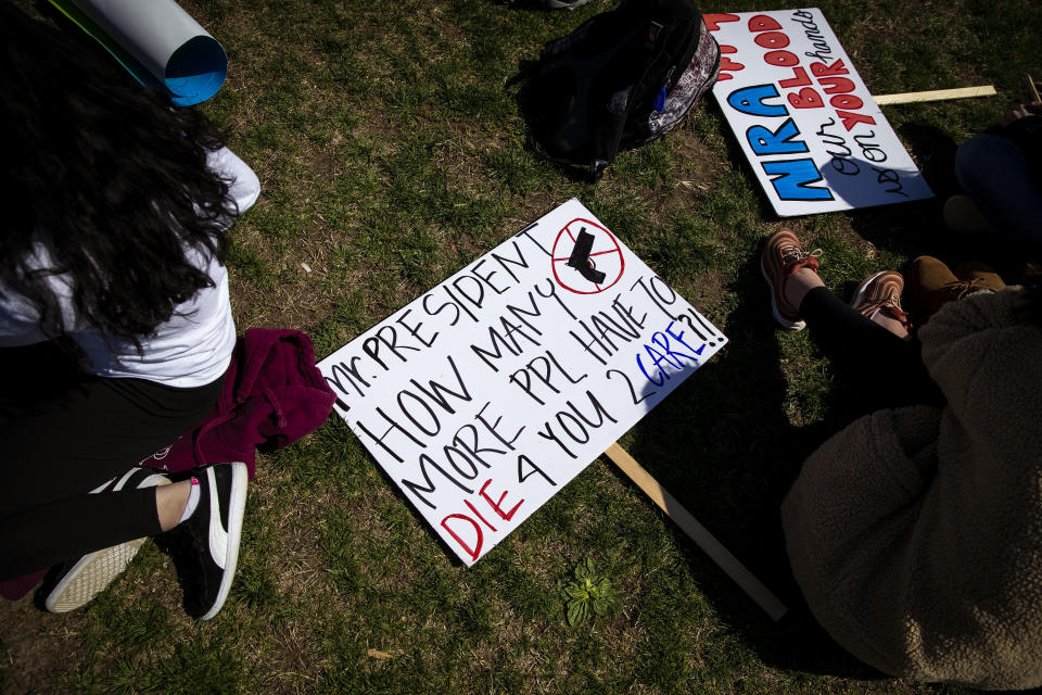 A sign that reads 'Mr. President How Many More People Have To Die For You To Care?! ' lays on the ground.