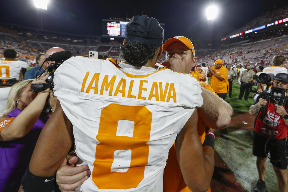 Tennessee head coach Josh Heupel speaks to quarterback Nico Iamaleava (8) after their team defeated Oklahoma during an NCAA college football game Saturday, Sept. 21, 2024, in Norman, Okla. (AP Photo/Alonzo Adams)