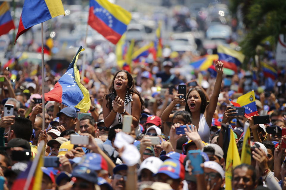 In this Saturday, March 16, 2019 photo, people cheer for Venezuelan opposition leader Juan Guaido, who declared himself interim president, at a rally in Valencia, Venezuela. Large crowds gathered in the northern Venezuelan city to greet Guaido, who plans to tour the country as part of his campaign to oust President Nicolas Maduro. (AP Photo/Fernando Llano)