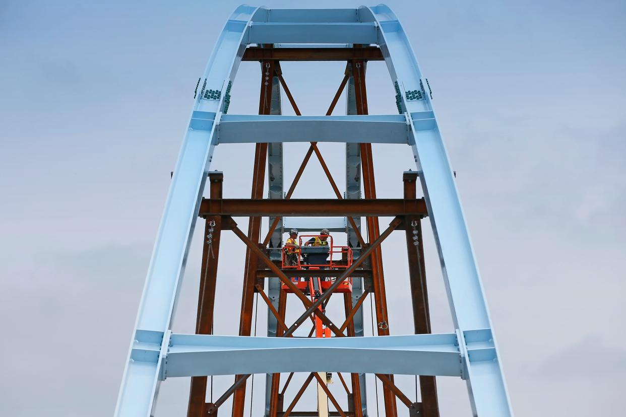 Iron workers torque the bolts of the beams creating the arches for the new pedestrian bridge being constructed over Route 18 in New Bedford.