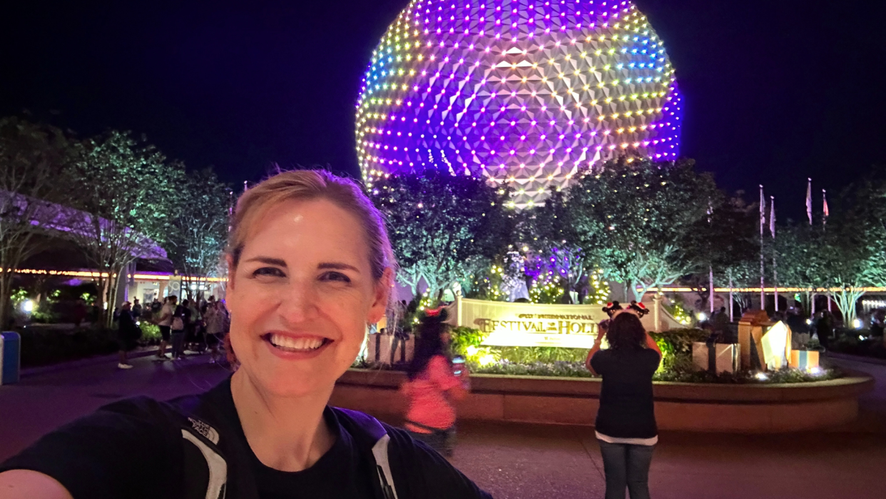 Jennifer Ferguson smiles as color illuminate Spaceship Earth at EPCOT.