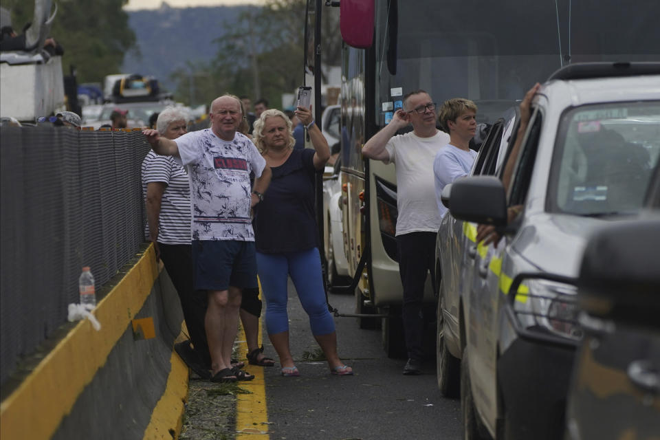 People wait outside their cars as they wait for repair crews to clear the roads after Hurricane Otis ripped through Acapulco, Mexico, Wednesday, Oct. 25, 2023. Hurricane Otis ripped through Mexico's southern Pacific coast as a powerful Category 5 storm, unleashing massive flooding, ravaging roads and leaving large swaths of the southwestern state of Guerrero without power or cellphone service. (AP Photo/Marco Ugarte)