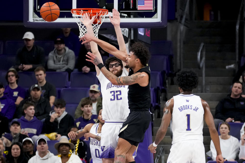 Colorado guard J'Vonne Hadley passes the ball past Washington forward Wilhelm Breidenbach (32) during the first half of an NCAA college basketball game Wednesday, Jan. 24, 2024, in Seattle. (AP Photo/Lindsey Wasson)